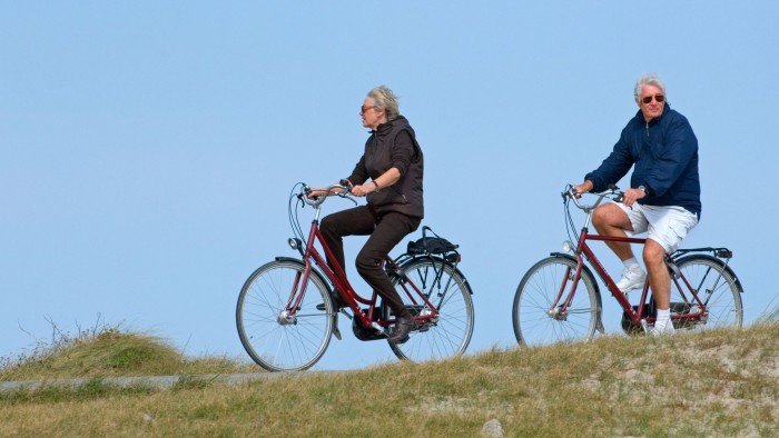 BEMBNW Elderly cyclists on bicycles riding in the dunes along the North Sea coast