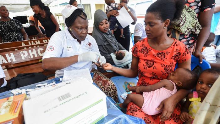 Health official takes blood sample of a mother for malaria testing at Ajah in Eti Osa East district of Lagos, on April 21, 2016. Dozens of patients and community members received malaria testing and treatment from the non-governmental organisation Development Africa, which in collaboration with Total company distributes treated mosquito nets and other actions to prevent malaria attacks to mark this year's World Malaria Day. / AFP / PIUS UTOMI EKPEI (Photo credit should read PIUS UTOMI EKPEI/AFP/Getty Images)