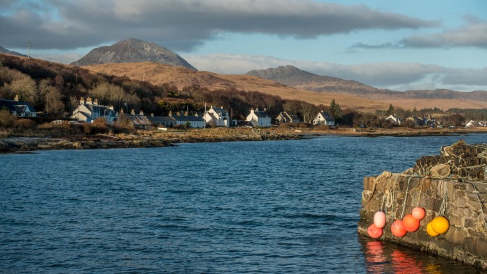 KXWW4J Scottish houses dotting the shoreline of Craighouse with the Paps Of Jura as a backdrop, Isle of Jura, Scotland