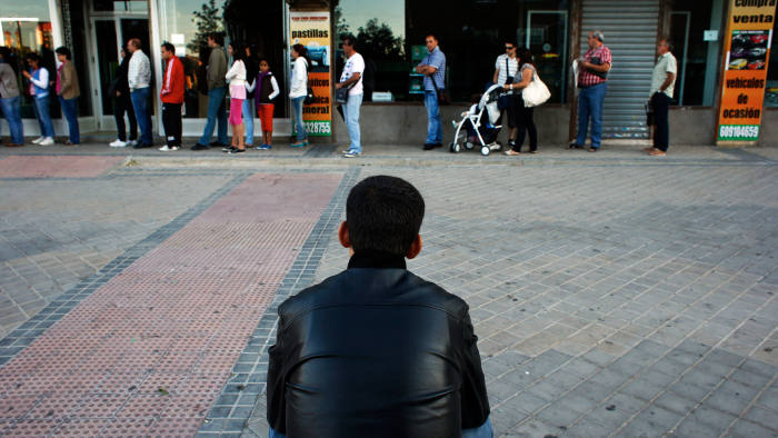 People wait to enter a government-run employment office in Madrid September 4, 2012