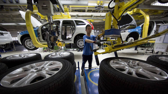 In this photo taken Tuesday, April 21, 2015, a worker installs wheels on a car at a Volvo factory in Chengdu in southwestern China's Sichuan province. On the verge of exporting the first “Made in China” cars to the United States, Volvo is determined to show they are as good as vehicles it produces in Europe. (AP Photo/Ng Han Guan)