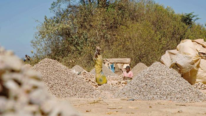 Women workers stand among rocks extracted from a cobalt mine at a copper quarry and cobalt pit in Lubumbashi on May 23, 2016. The price of copper has fallen heavily, directly impacting workers in the town. / AFP / JUNIOR KANNAH (Photo credit should read JUNIOR KANNAH/AFP/Getty Images)