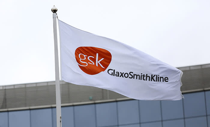 GlaxoSmithKline Plc Chief Finance Officer Simon Dingemans Speaks On 2014 Profit...A GlaxoSmithKline Plc logo sits on a flag as it flies outside the company's headquarters in London, U.K., on Wednesday, Feb. 5, 2014. GlaxoSmithKline, the U.K.'s biggest drugmaker, forecast that revenue will rise by about 2 percent this year as it introduces new medicines. Photographer: Chris Ratcliffe/Bloomberg