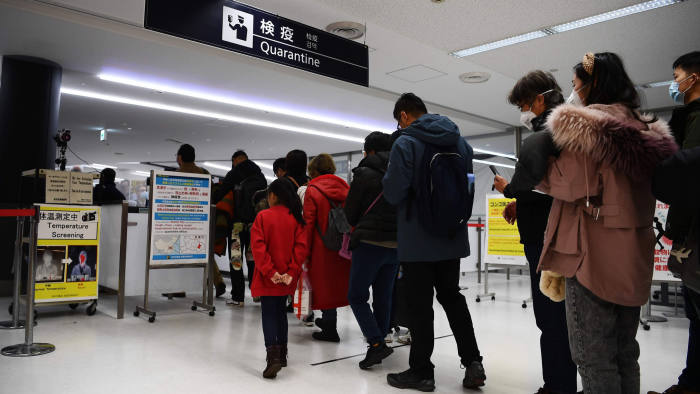 Passengers who arrived on one of the last flights from the Chinese city of Wuhan walk through a health screening station at Narita airport in Chiba prefecture, outside Tokyo, on January 23, 2020, as countries screen for anyone showing symptoms of a SARS-like virus which has killed at least 17 people and infected over 500. - China banned trains and planes from leaving Wuhan at the centre of a virus outbreak on January 23, seeking to seal off its 11 million people to contain the contagious disease that has claimed 17 lives, infected hundreds and spread to other countries. (Photo by CHARLY TRIBALLEAU / AFP) (Photo by CHARLY TRIBALLEAU/AFP via Getty Images)