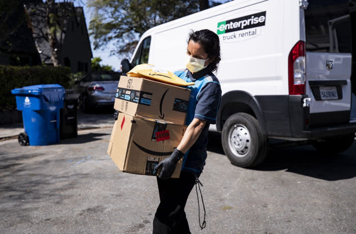 Mandatory Credit: Photo by ETIENNE LAURENT/EPA-EFE/Shutterstock (10595098a) An Amazon delivery woman delivers packages amid the coronavirus pandemic in Los Angeles, California, USA, 26 March 2020. The United States is bracing for the massive economic impact of the ongoing coronavirus pandemic. According to the US Department of Labor there were over three million jobless claims during the week that ended on 21 March. Daily life amid coronavirus pandemic, in Los Angeles, USA - 26 Mar 2020