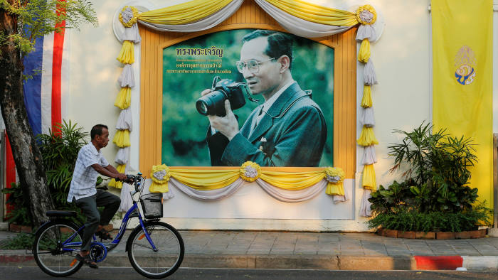A man cycles past a picture of Thailand's King Bhumibol Adulyadej in central Bangkok, Thailand, April 17, 2016. REUTERS/Jorge Silva SEARCH "SILVA THRONE" FOR THIS STORY. SEARCH "THE WIDER IMAGE" FOR ALL STORIES - RTSGNBS