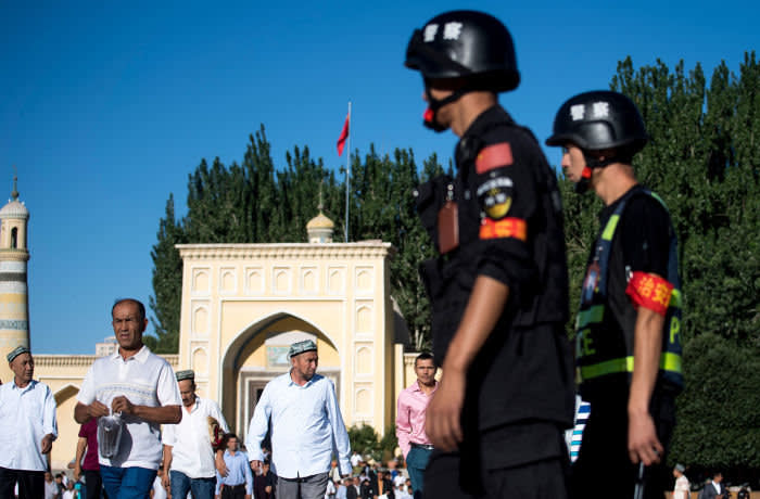 (FILES) This file photo taken on June 26, 2017 shows police (R) patrolling as Muslims leave the Id Kah Mosque after morning prayer during Eid al-Fitr in Kashgar in China's Xinjiang Uighur Autonomous Region. China's construction of a vast, all-seeing police state in its fractious far west has triggered a government spending spree worth billions to firms providing a hi-tech network of cameras and "re-education centres". The surveillance machine in Xinjiang region has grown exponentially in recent years, used by the ruling Communist Party to guard against what it considers Islamic extremism and separatism in the region. / AFP PHOTO / JOHANNES EISELE / TO GO WITH: CHINA-SECURITY-RIGHTS; Focus by Ben DOOLEYJOHANNES EISELE/AFP/Getty Images
