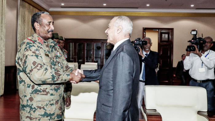 Arab League Secretary General Ahmed Aboul Gheit (C) shakes hands with Sudan's ruling Transitional Military Council (TMC) chief Abdel Fattah al-Burhan (L) in the capital Khartoum on June 16, 2019. (Photo by - / AFP) (Photo credit should read -/AFP/Getty Images)