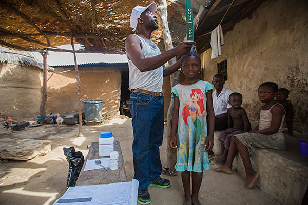 Six-year-old Pinkwat Luka of Amper, Nigeria, is being measured by a community directed distributor (CDD) to ensure that she receives the correct dose of medicine
