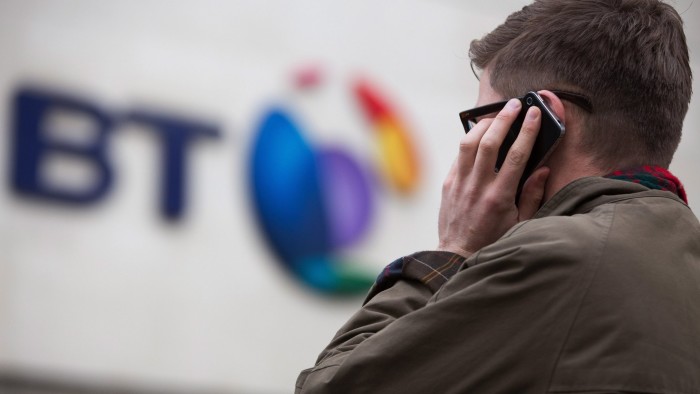 A pedestrian uses a smartphone in this arranged photograph taken outside BT Group Plc's headquarters in London, U.K., on Monday, Dec. 15, 2014. BT started exclusive talks to acquire Deutsche Telekom AG and Orange SA's British wireless venture EE for 12.5 billion pounds ($19.6 billion), moving ahead with a deal that's set to spur more mergers in the U.K. telecommunications market. Photographer: Jason Alden/Bloomberg