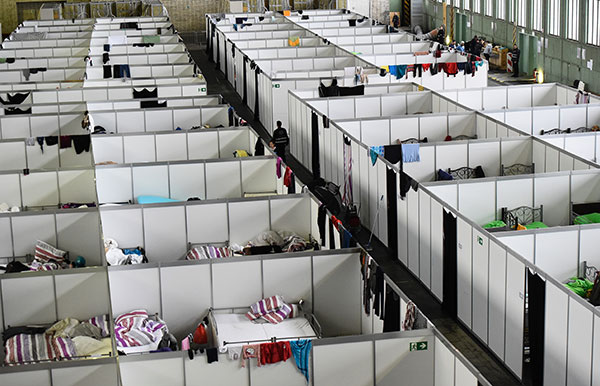 View into rooms in lightweight construction where clothes are hung up at the refugee accomodation at the former Tempelhof airport in Berlin on December 9, 2015.