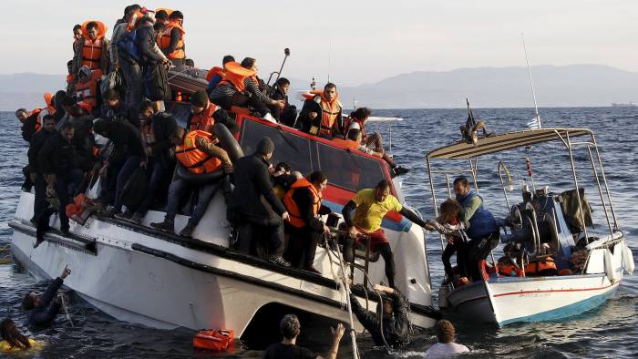 A Greek fishing boat (R) evacuates people from a half-sunken catamaran carrying around 150 refugees, most of them Syrians arriving after crossing part of the Aegean sea from Turkey, on the Greek island of Lesbos, October 30, 2015. There were no casaulties amongst the refugees who were travelling on the catamaran, according to a Reuters witness. The death toll from drownings at sea has mounted recently as weather in the Aegean has taken a turn for the worse, turning wind-whipped sea corridors into deadly passages for thousands of refugees crossing from Turkey to Greece. REUTERS/Giorgos Moutafis