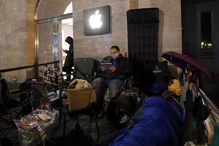 epa06305089 A customer looks at his mobile device as he camps and queues for the release of Apple's new iPhone X in front of the Apple Store in Berlin, Germany, early 03 November 2017. Apple will release its new Apple iPhone X in many countries worldwide on 03 November 2017. EPA/FELIPE TRUEBA