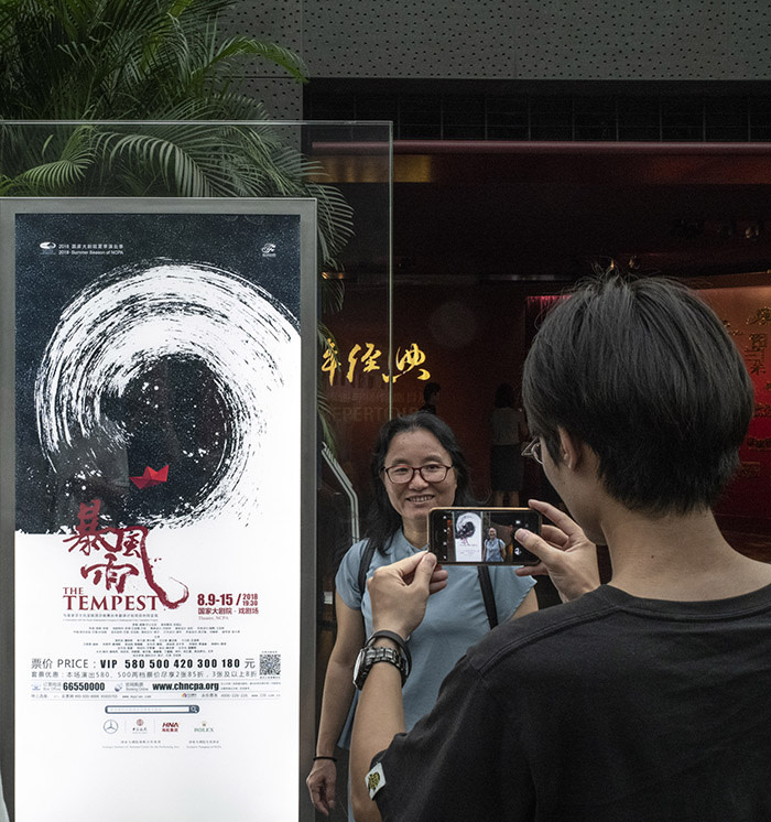 Beijing August 15th, 2018 At the National Centre for Performing Arts, spectators taking souvenir photos with a poster of a a Chinese Production of Shakespeare's The Tempest, before the performance. Gilles SabriÈ for The Financial Times