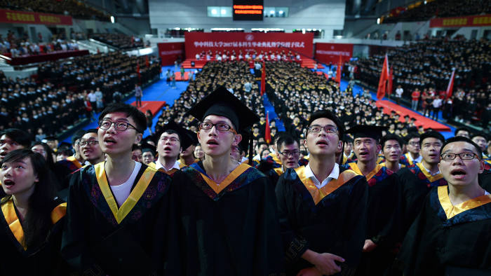 This photo taken on June 20, 2017 shows students from the Huazhong University of Science and Technology singing during their graduation ceremony in a sports stadium in Wuhan, in China's central Hubei province. Over 7,000 students took part in the graduation ceremony. / AFP PHOTO / STR / China OUT (Photo credit should read STR/AFP/Getty Images)