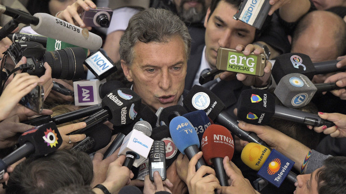 Buenos Aires Mayor and presidential candidate for &quot;Cambiemos&quot; party Mauricio Macri (C) is hounded by the media after voting in Buenos Aires on October 25, 2015
