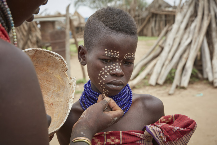 A youth has his face painted in Dus, Ethiopia, September 2017. A sustainable travel venture is working to build mutually beneficial exchanges between tourists and the local peoples in Ethiopia's Omo Valley, where dams are threatening to upend traditional tribal life. (Andy Haslam/The New York Times) Credit: New York Times / Redux / eyevine For further information please contact eyevine tel: +44 (0) 20 8709 8709 e-mail: info@eyevine.com www.eyevine.com
