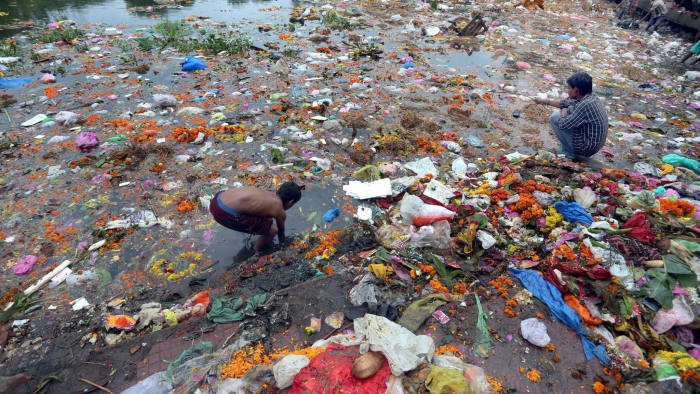 Young ragpickers collect clothes, coins, wooden materials and other usable items cluttered at the bank of Jawahar Lal Nehru lake...epa04391999 Young ragpickers collect clothes, coins, wooden materials and other usable items cluttered at the bank of the Jawahar Lal Nehru lake after the immersion of Lord Ganesh idols to mark the end of the Ganesh festival, in Bhopal, India, 09 September 2014. Despite of the warning of the district administration not to immerse idols in the lake to protect the environment, hundreds of idols have been immersed by devotees, resulting in a huge pollution of the lakes in India. EPA/SANHEEV GUPTA