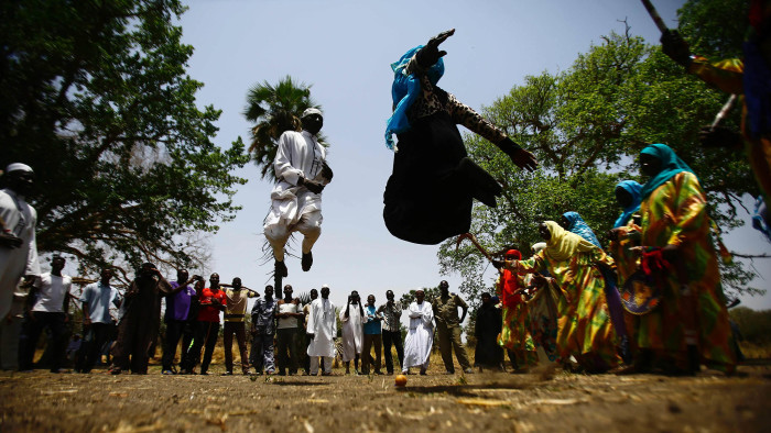 Sudanese people dance at the Um Bager market near the Dinder national reserve, a protected region 480 kilometres from the capital Khartoum, in Sudan's southern Sennar state on April 15, 2017. / AFP PHOTO / ASHRAF SHAZLYASHRAF SHAZLY/AFP/Getty Images
