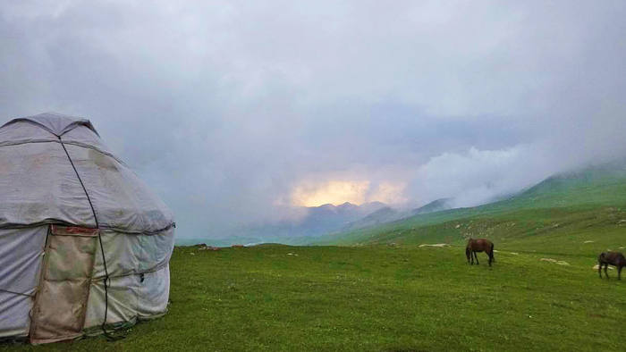 Robin’s yurt and horses grazing under clearer skies after a dramatic rain storm