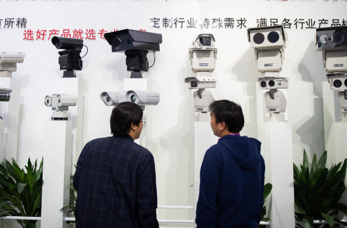 Visitors look at AI (Artificial Inteligence) security cameras using facial recognition technology at the 14th China International Exhibition on Public Safety and Security at the China International Exhibition Center in Beijing on October 24, 2018. (Photo by NICOLAS ASFOURI / AFP) (Photo credit should read NICOLAS ASFOURI/AFP via Getty Images)