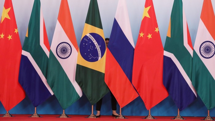 A member of staff stands behind national flags of Brazil, Russia, China, South Africa and India to tidy the flags ahead a group photo during the BRICS Summit at the Xiamen International Conference and Exhibition Center in Xiamen, southeastern China's Fujian Province on September 4, 2017. 
Xi opened the annual summit of BRICS leaders that already has been upstaged by North Korea's latest nuclear weapons provocation. / AFP PHOTO / POOL / WU HONG        (Photo credit should read WU HONG/AFP/Getty Images)