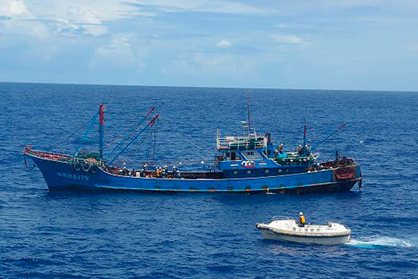 A Chinese fishing boat is inspected by a Japanese vessel