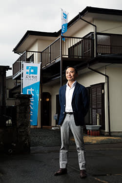 Katsutoshi Arai, the president of Katitas, in front of a renovated house