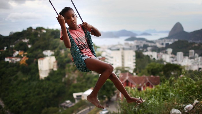 RIO DE JANEIRO, BRAZIL - MARCH 22: A child plays on a swing in the Prazeres pacified favela community on March 22, 2014 in Rio de Janeiro, Brazil. The favela was previously controlled by drug traffickers but is now occupied by the city's Police Pacification Unit (UPP). A number of UPPs were attacked by drug gang members on March 20, prompting some pacified favelas to soon receive federal forces as reinforcements. The UPP is patrolling some of Rio's favelas amid the city's efforts to improve security ahead of the 2014 FIFA World Cup and 2016 Olympic Games. (Photo by Mario Tama/Getty Images)