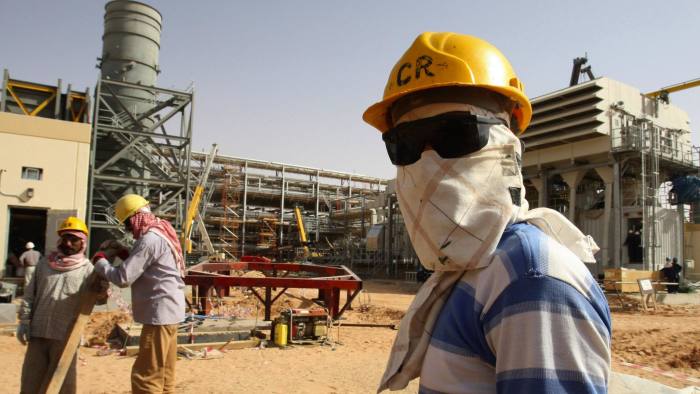 A worker looks at journalists during a media tour of the Khurais oilfield, about 160 km (99 miles) from Riyadh, June 23, 2008. State oil giant Saudi Aramco is adamant the biggest new field in its plan to raise oil capacity will arrive bang on schedule in June next year. REUTERS/Ali Jarekji (SAUDI ARABIA)