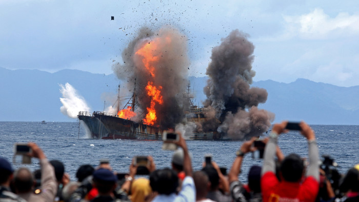 People take pictures of a burning ship as the government destroyed foreign boats that had been caught illegally fishing in Indonesia waters, at Morela village in Ambon island, April 1, 2017 in this photo taken by Antara Foto. Picture taken April 1, 2017. Antara Foto/Izaac Mulyawan/via REUTERS ATTENTION EDITORS - THIS IMAGE WAS PROVIDED BY A THIRD PARTY. FOR EDITORIAL USE ONLY. MANDATORY CREDIT. INDONESIA OUT. TPX IMAGES OF THE DAY