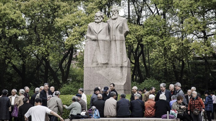 People chat in front of a statue of Karl Marx and Friedrich Engels at Fuxing Park in Shanghai, China, on Sunday, April 10, 2016. China's economy stabilized last quarter and gathered pace in March as a surge in new credit helped the property sector rebound while raising fresh question marks over the sustainability of the debt-fueled expansion. Photographer: Qilai Shen/Bloomberg