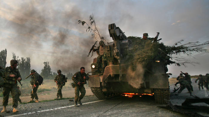 GORI, GEORGIA - AUGUST 11: (ISRAEL OUT)  Georgian soldiers escape their burning armoured vehicle on the road to Tbilisi on August 11, 2008 just outside Gori, Georgia. Russia called today for Georgian forces to surrender in the separatist enclave of Abkhazia after Georgia called a ceasefire and withdrew their forces from South Ossetia, leaving Russian forces now firmly in control in the disputed region.  (Photo by Uriel Sinai/Getty Images)