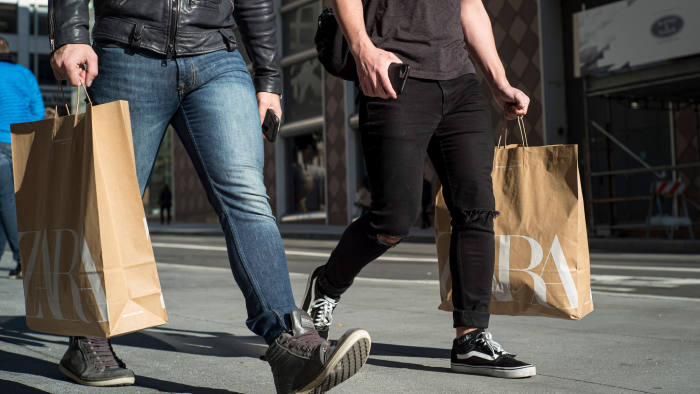 Pedestrians carry shooting bags from Zara fashion store, operated by Inditex SA, in San Francisco, California, U.S., on Thursday, Dec. 26, 2019. Confidence among U.S. consumers advanced to a nine-week high on greater optimism about the economy and brighter views of personal finances and the buying climate. Photographer: David Paul Morris/Bloomberg