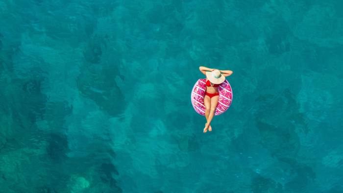 Aerial view of swimming woman in clear turquoise water. Mediterranean sea.