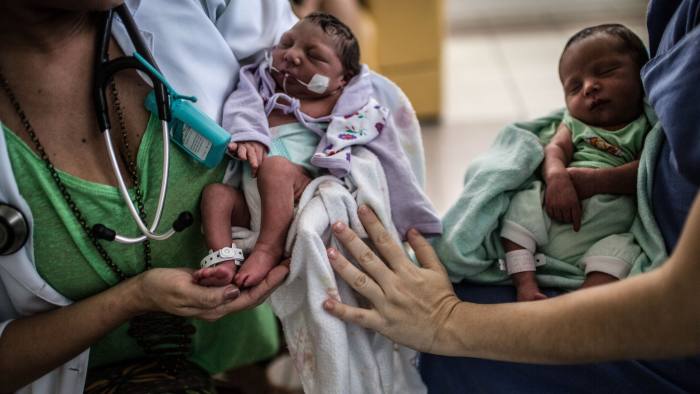 A mother of twins, right, talks to her doctor, holding the baby with microcephaly IMIP, a public hospital in Recife, Brazil, Thursday, Januar aty, 21, 2016. The city has been the national epicenter of hundreds of cases of microcephaly linked to a Zika virus outbreak that has its roots on poor sanitation, unattended garbage and urban sprawl. These factors contribute to Aedes aegypt mosquitoes' proliferation and along with them the viruses that use it as vector, like dengue, zika and chikungunya. (Dado Galdieri via Hilaea Media for The Wall Street Journal)(Hilaea Media/Dado Galdieri for Financial Times)

