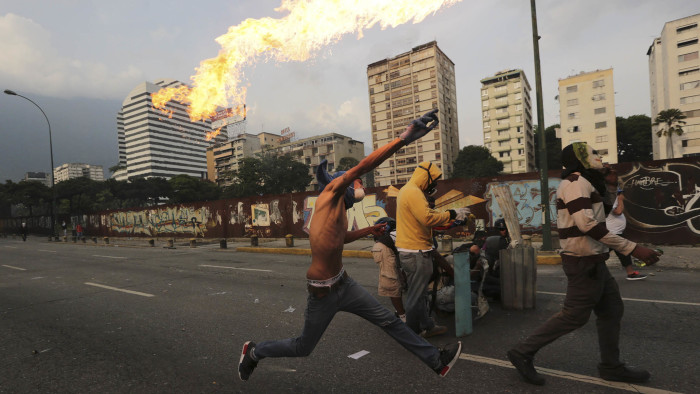 An anti-government protesters throws a molotov bomb at security forces in Caracas, Venezuela, Wednesday, April 19, 2017. Tens of thousands of opponents of President Nicolas Maduro flooded the streets of Caracas in what's been dubbed the &quot;mother of all marches&quot; against the embattled socialist president. (AP Photo/Fernando Llano)