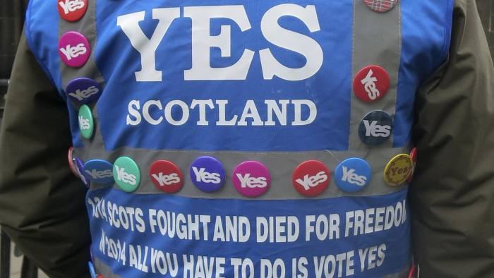A man wears 'Yes' campaign badges during a pro-independence march in