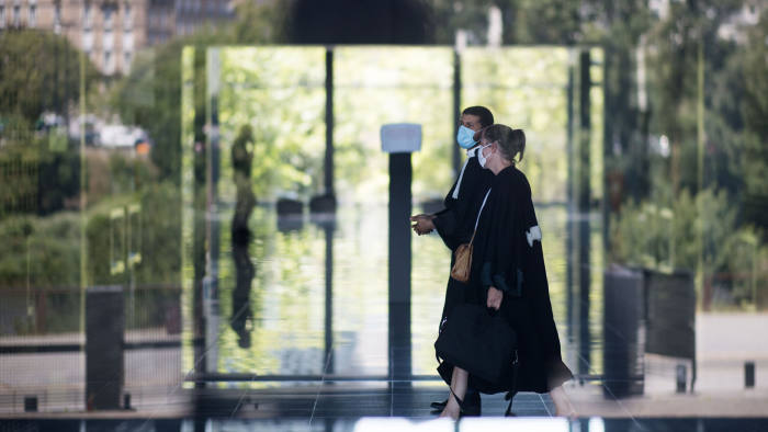 Lawyers wearing face masks walk down a corridor on May 26, 2020 at the courthouse in Nantes, western France, amid the crisis caused by the Covid-19 pandemic (novel coronavirus). (Photo by Loic VENANCE / AFP) (Photo by LOIC VENANCE/AFP via Getty Images)