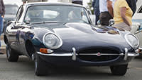 Dartmouth, Nova Scotia, Canada - June 14, 2012: At a public car gathering, a Jaguar E-Type parked in a parking lot. Many people are visible admiring the cars and some other vehicles are visible in the background and beside Jaguar.