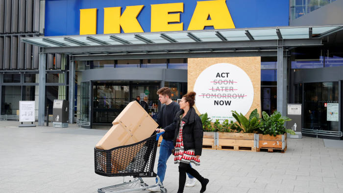 FILE PHOTO: Customers walk by a placard reading "Act Now" as they leave the IKEA store in Kaarst near Duesseldorf, Germany, April 3, 2019. REUTERS/Wolfgang Rattay/File Photo