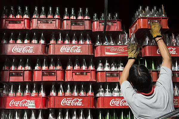A worker loads a delivery truck with empty Coca-Cola bottles in Mexico City, Mexico, on Thursday, Sept. 5, 2013