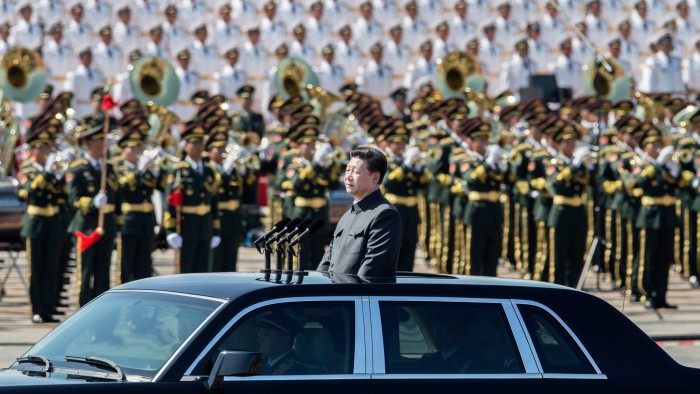 Chinese president and leader of the Communist Party Xi Jinping rides in an open top car in front of Tiananmen Square and the Forbidden City during a military parade on September 3 2015 in Beijing, China