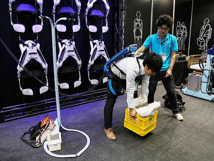 A visitor tries Innophys wearable robot Muscle Suit during the Japan Robot Week 2014 in Tokyo, Oct, 16, 2014. Photo by Haruyoshi Yamaguchi (Photo by Yamaguchi Haruyoshi/Corbis via Getty Images)