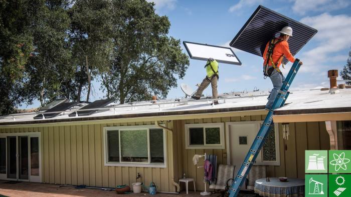PetersenDean Inc. employees carry solar panels onto the roof of a home in Lafayette, California, U.S., on Tuesday, May 15, 2018. California became the first in the U.S. to require solar panels on almost all new homes. Most new units built after Jan. 1, 2020, will be required to include solar systems as part of the standards adopted by the California Energy Commission. Photographer: David Paul Morris/Bloomberg