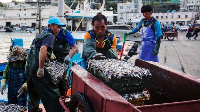 Fishermen unload crates of freshly caught anchovies from a boat at Mijo port in Namhae, South Korea, on Tuesday, April 19, 2016. South Korea is scheduled to release preliminary first-quarter gross domestic product figures on April 26. Photographer: SeongJoon Cho/Bloomberg