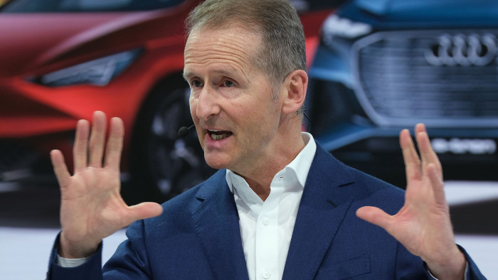 WOLFSBURG, GERMANY - MARCH 12: Herbert Diess, CEO of German automaker Volkswagen AG, stands in front of pictures of electric cars from the various VW-owned brands as he speaks at the company's annual press conference at Volkswagen headquarters on March 12, 2019 in Wolfsburg, Germany. Diess said he is committing the company to an electric car future and has set ambitious greenhouse gas reduction goals for the VW by aiming to make the entire company CO2 neutral by 2050. (Photo by Sean Gallup/Getty Images)