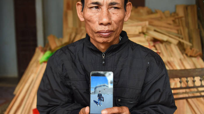 Nguyen Dinh Gia, father of 20-year-old Nguyen Dinh Luong who is feared to be among the 39 people found dead in a truck in Britain, poses with his son's photograph at their house in Can Loc district of Vietnam's Ha Tinh province on October 29, 2019. - Initially identified as Chinese, many of the 39 people who were found dead in a truck in Britain are now believed to be Vietnamese after families came forward saying they feared their relatives were in the refrigerated trailer. (Photo by Nhac NGUYEN / AFP) (Photo by NHAC NGUYEN/AFP via Getty Images)