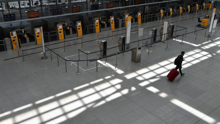 TOPSHOT - A passenger walks in an empty Lufthansa terminal at the 