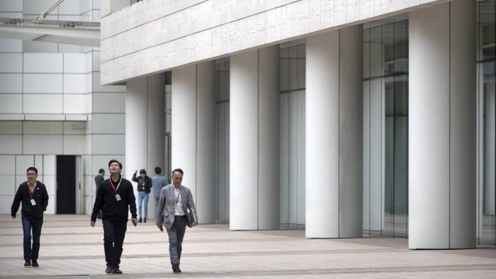 Employees walk through Huawei's campus in Shenzhen in southern China's Guandong Province, Thursday, Dec. 5, 2019. Chinese tech giant Huawei is asking a U.S. federal court to throw out a rule that bars rural phone carriers from using government money to purchase its equipment on security grounds. (AP Photo/Mark Schiefelbein)